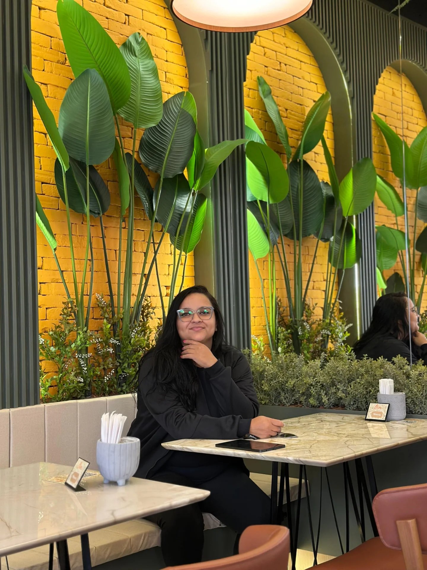 Karina da Cruz, fundadora da Bikavi, em ambiente com composição botânica