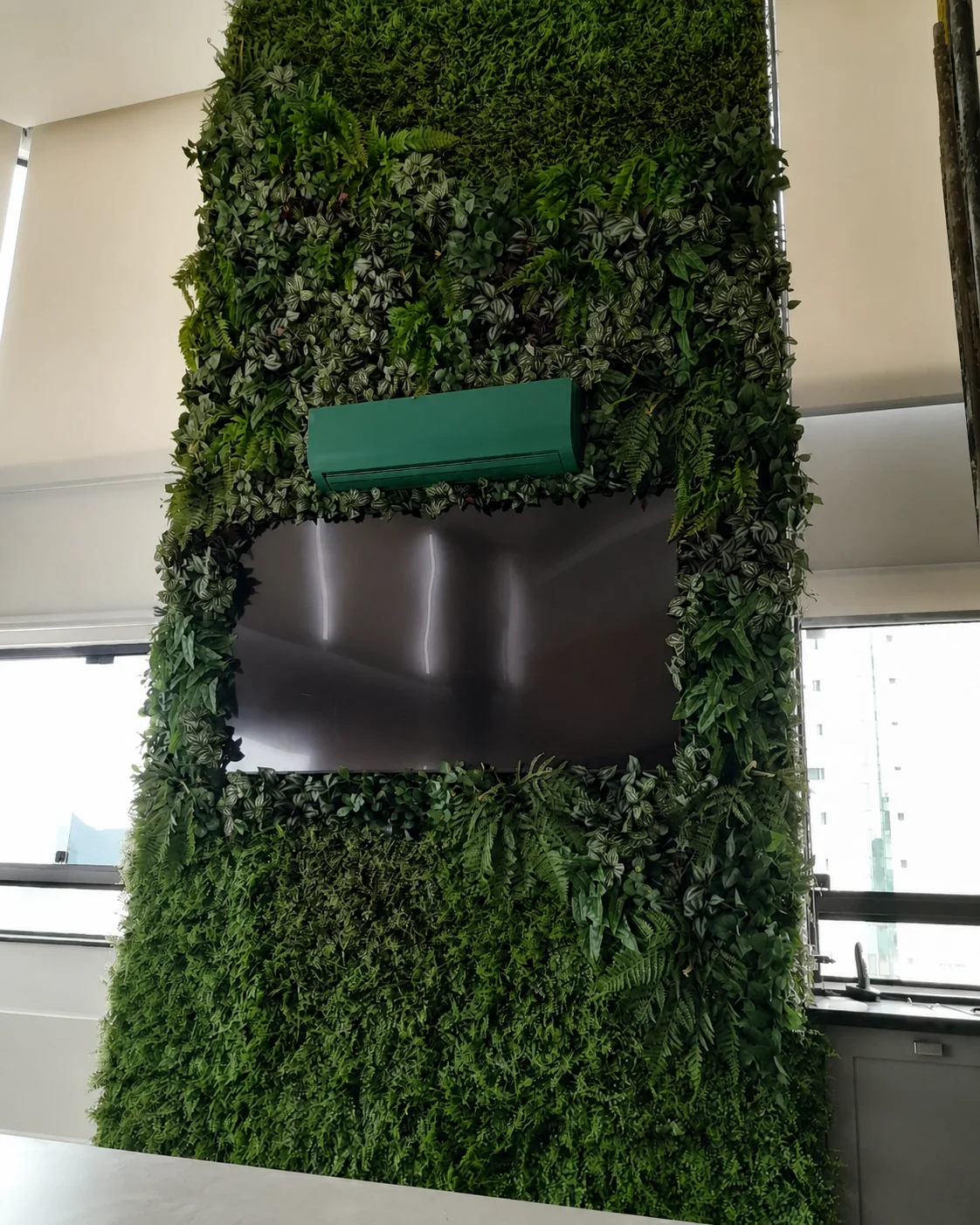 Jardim vertical envolvendo televisão em ambiente corporativo